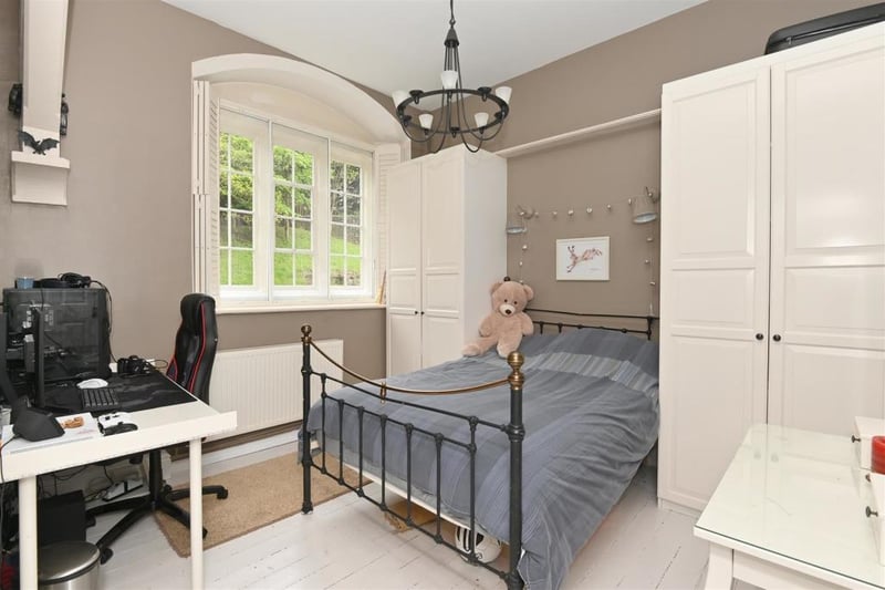 This roomy double bedroom on the ground floor has a wooden floor and stone mullion window with double-glazing panel and fitted wooden shutters. There is a radiator and high ceiling with light fitting.