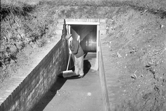 A worker does some cleaning up to keep this air raid shelter spotless in 1941.