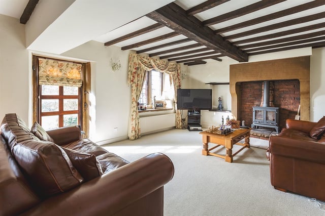 A generous sized sitting room having south aspect, a full length hardwood window looking across the lawn, exposed beams to ceiling, built-in display shelving under the internal window and a pair of French doors opening into the dining room.