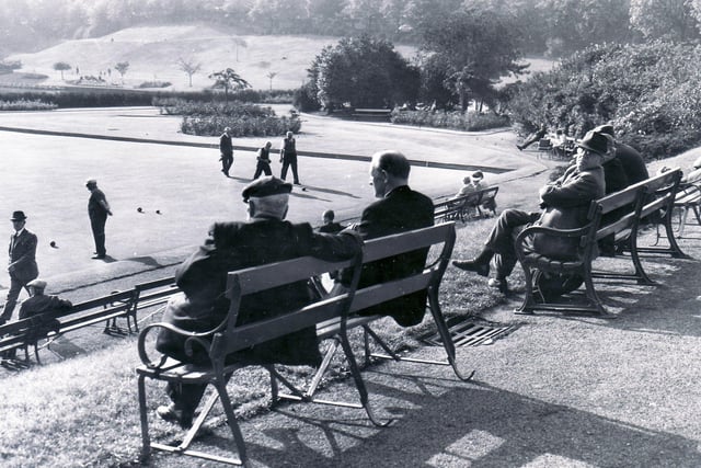 People sitting in the autumn sunshine watching a leisurely game of Bowls at Crookes Valley Park in 1966.