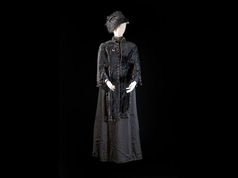 This outfit represents death as well as the diaspora. The original owner was sent the costume by her son in the United States, who had emigrated in the late 1800s but who regularly sent parcels of clothes home to his mother.