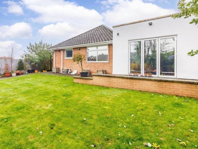 Another view of the Berry Hill bungalow from the rear, showing the large lawn and orangery extension.