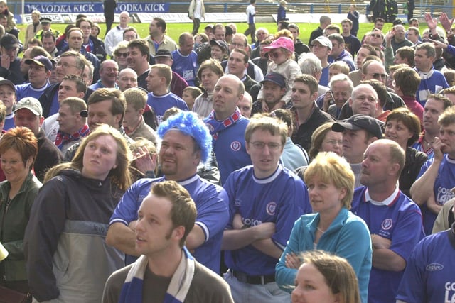 Fans wait on the pitch in front of the directors' box.