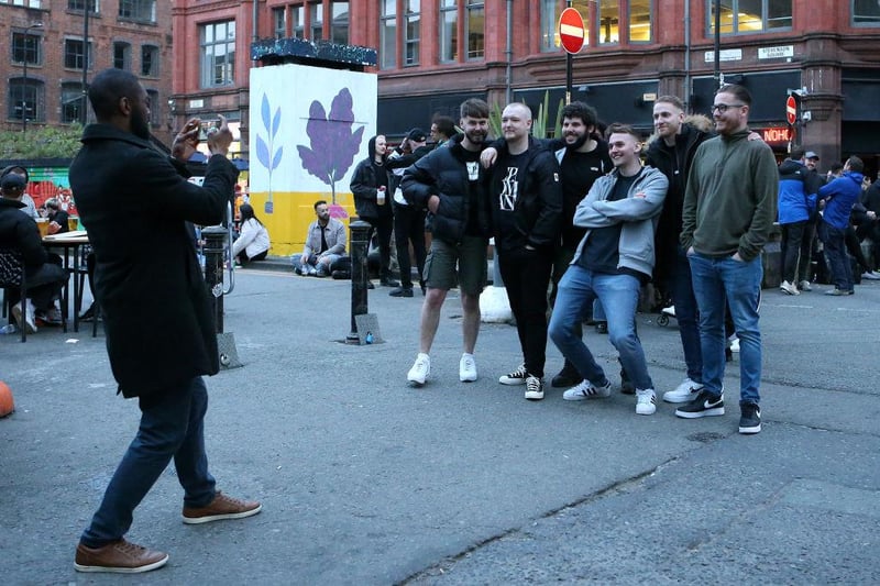 A group of men are seen having their photograph taken on the streets of Manchester's Northern Quarter on April 16, 2021 in Manchester, England. (Photo by Charlotte Tattersall/Getty Images)