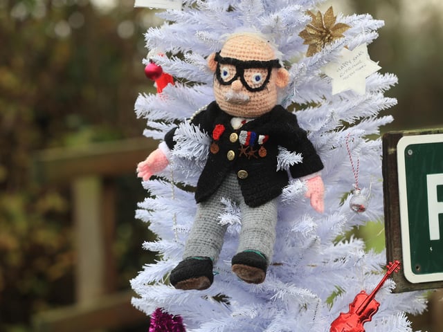 A hand knitted Christmas bauble of Captain Sir Tom Moore hangs on the village Christmas tree in the centre of Allington, Lincolnshire.