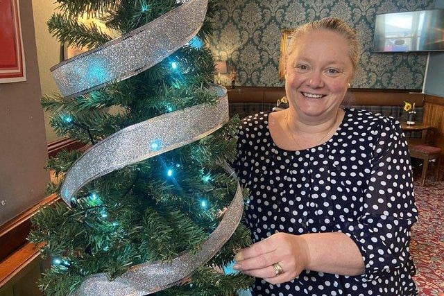 The Nursery Inn pub manager Deborah Humberston decorating a Christmas tree ahead of the pub's May 30 carol service.