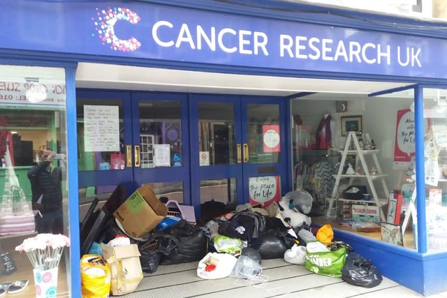 Shoppers have left bags of donations outside Cancer Research in Alnwick, despite a notice in the window asking them not to do so.