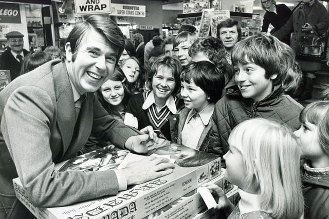 Television presenter Leslie Crowther, of Crackerjack fame, pictured at Redgates toy store in Sheffield, surrounded by a crowd of smiling youngsters, on November 22, 1975