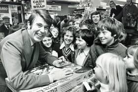 Television presenter Leslie Crowther, of Crackerjack fame, pictured at Redgates toy store in Sheffield, surrounded by a crowd of smiling youngsters, on November 22, 1975