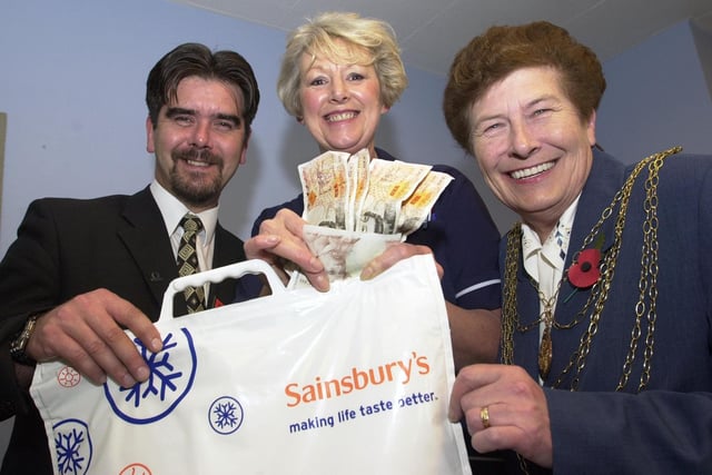 The Mayor of Doncaster, Councillor Maureen Edgar, and Carol Spiller, Cancer Detection Board member, accept £450 from Stephen Ronan, Doncaster Sainsbury's duty manager, on behalf of the St John's Hospice, Balby. The presentation took place at the Frenchgate store in 2000