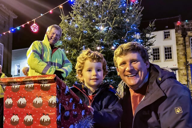 Three-year-old James Abercrombie was chosen to switch the lights on. He is pictured with his dad, Richard, a member of the Christmas lights committee, and chairman Gordon Castle.