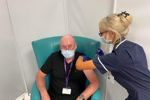 Michael Burnell who works supporting the Sheffield Hospitals Pharmacy team aged 81 having his vaccination from Sister Amber Mills.