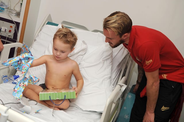James Coppinger watches four-year-old Archie Butterton of Sprotbrough open a gift during the visit of the children's ward at Doncaster Royal Infirmary during Christmas 2013