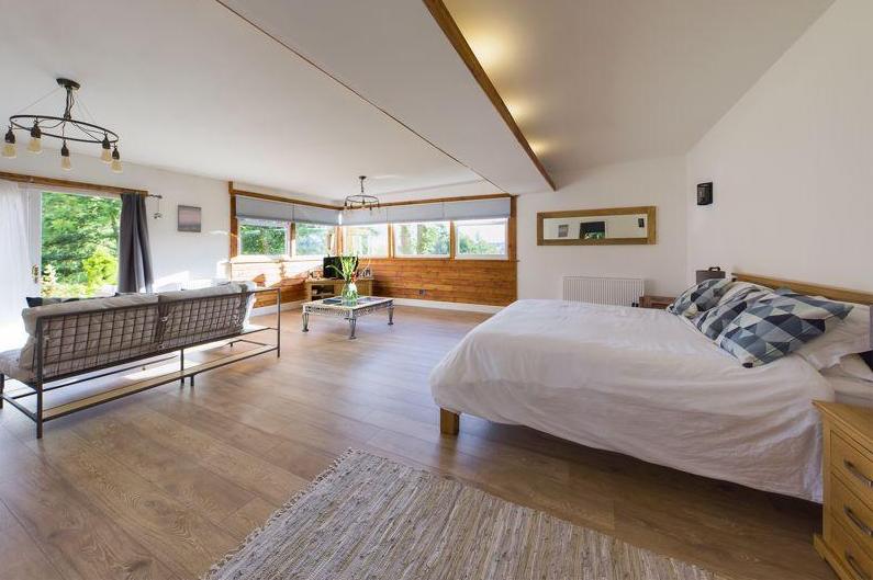 The master bedroom has access to a raised external decking area, perfect to take in the views.