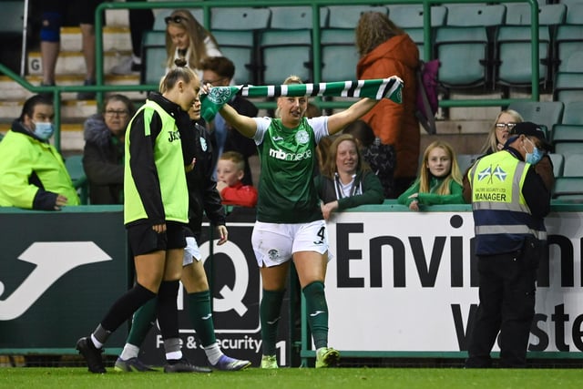 The defender celebrates the victory over Hearts by waving her Hibs scarf high.