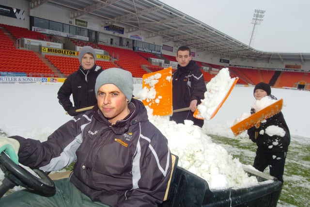 Keepmoat Stadium staff, volunteers, and the Doncaster Rovers youth team help to clear the snow from the pitch in 2010