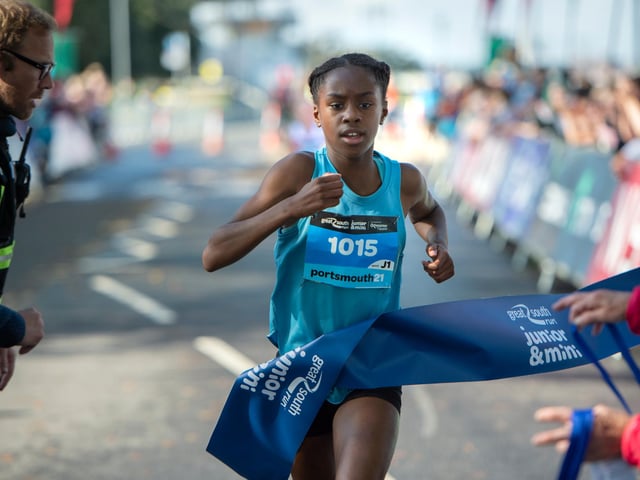 The winner of the girls' junior run crosses the finishing line. Photo: Peter Langdown