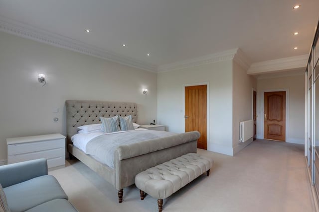 The luxurious master bedroom stretches the length of the house and has a range of fitted furniture incorporating short hanging, shelving and drawers. Oak doors open to the master en-suite and walk-in wardrobe.