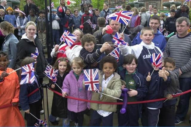 Children wave Union Jack flags during Queen Elizabeth II's visit to Sheffield in 2003.