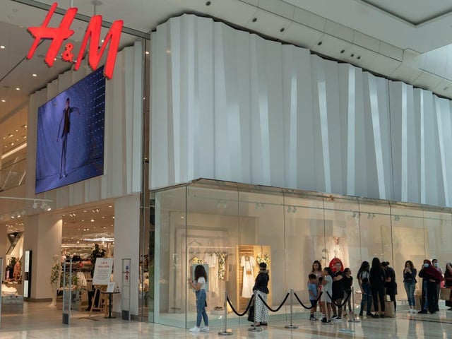 Shoppers wore face coverings as they waited in queues to enter a H&M brand inside the Westfield shopping centre in Shepherds Bush.