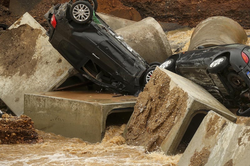 Cars lie in a washed out part of the Bessem district of Erftstadt, Germany, Friday, July 16, 2021. Heavy rains caused mudslides and flooding in the western part of Germany. Multiple have died and dozens are missing as severe flooding in Germany and Belgium turned streams and streets into raging, debris-filled torrents that swept away cars and toppled houses. (David Young/dpa via AP)