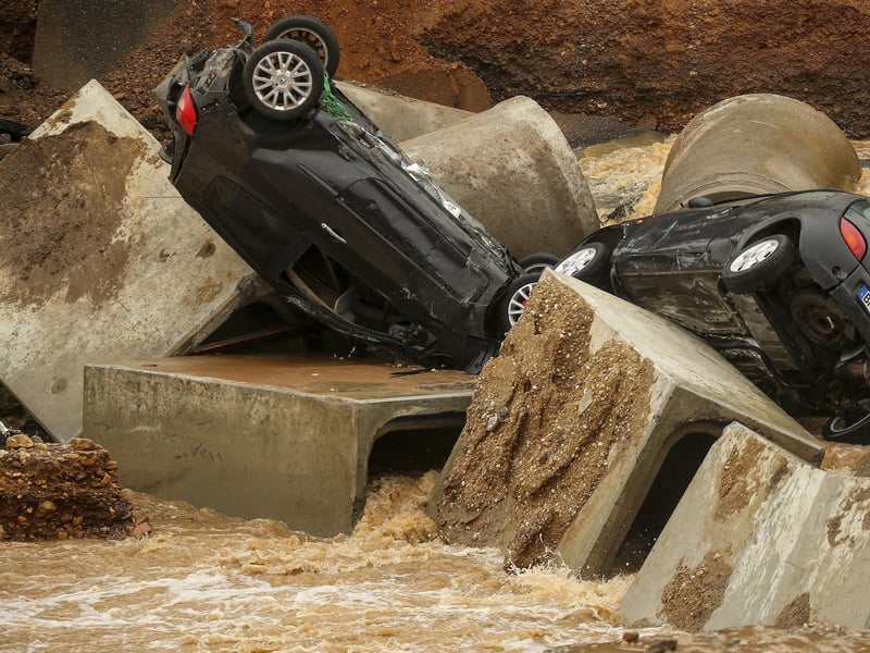Cars lie in a washed out part of the Bessem district of Erftstadt, Germany, Friday, July 16, 2021. Heavy rains caused mudslides and flooding in the western part of Germany. Multiple have died and dozens are missing as severe flooding in Germany and Belgium turned streams and streets into raging, debris-filled torrents that swept away cars and toppled houses. (David Young/dpa via AP)