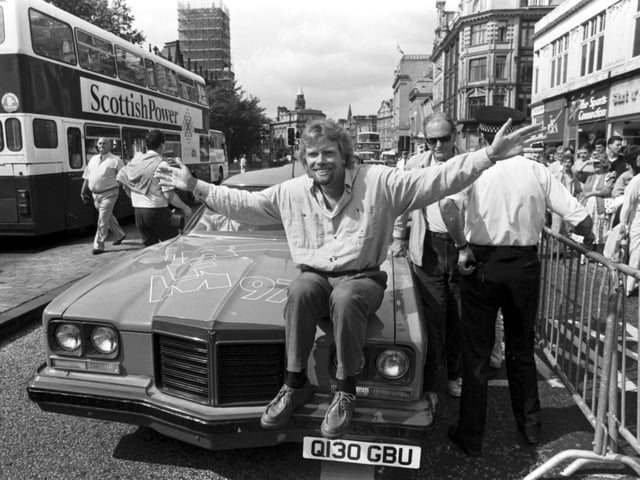 British businessman Richard Branson poses with his pink Pontiac car outside his new Virgin Megastore, opening in Edinburgh in July 1990.