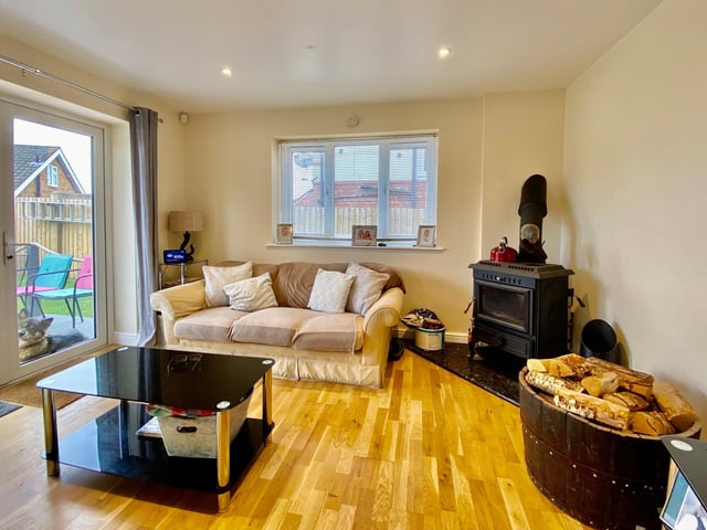 A log burner fire and patio doors to the rear garden in the corner of the open-plan kitchen/diner.