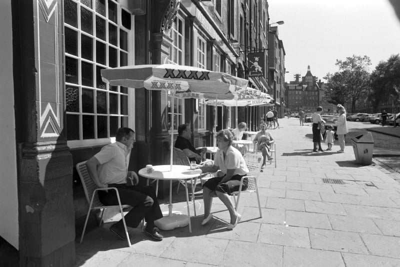 People drinking at tables on the pavement outside the White Hart Inn in Edinburgh's Grassmarket, June 1988.