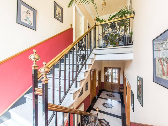 Here is the grand, sweeping staircase with more marble flooring