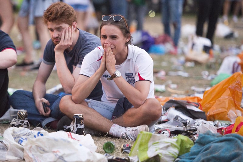 Disappointed fans sit among the rubbish after watching the England lose to Croatia - the match was shown on big screens at Devonshire Green in Sheffield