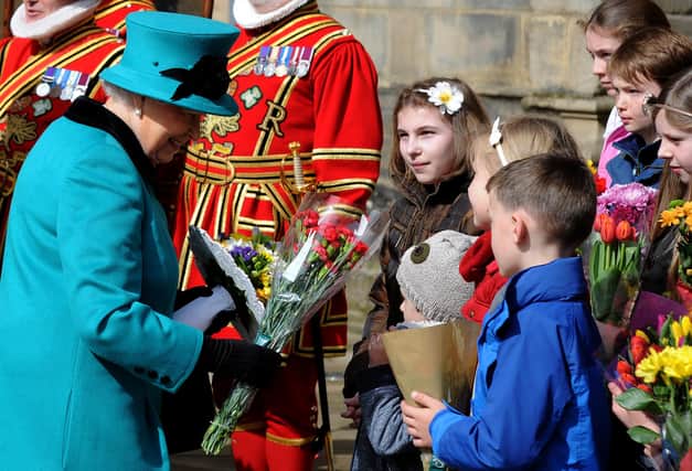 The Queen collects flowers from children outside Sheffield Cathedral for Maundy Thursday. Picture: Andrew Roe