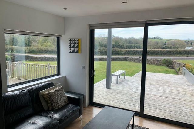 A 'spacious' living room with window to the side and sliding doors to the front accessing the garden.