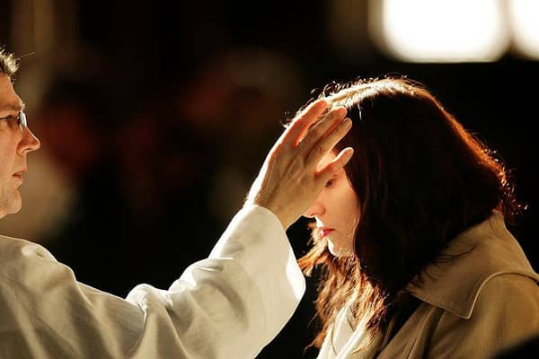 A worshipper receives a cross of ashes painted on her forehead during an Ash Wednesday service at the start of Lent