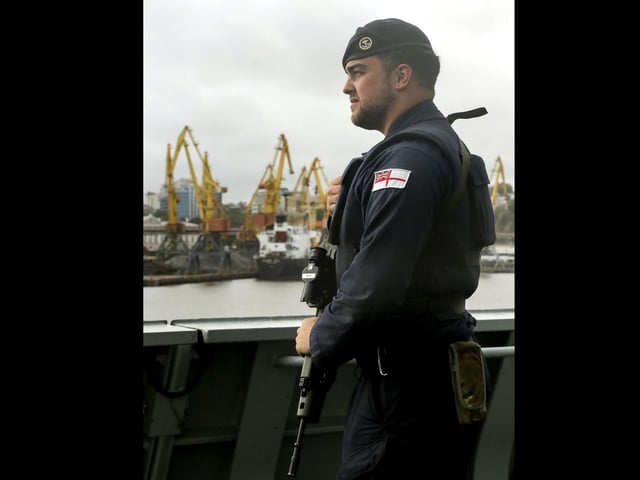 A Royal Navy Gunner stands guard on the upper deck as HMS Dragon sails into Odessa, Ukraine. Just days after entering the Black Sea HMS Dragon arrives in Odessa in preparation to play a key role in multi-international training objectives.