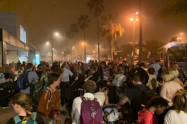Passengers waiting outside Tenerife South Airport for a coach during the sandstorm
