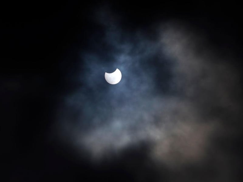A partial solar eclipse is seen through cloud cover from Primrose Hill in central London on June 10, 2021