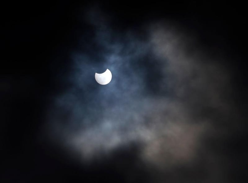 A partial solar eclipse is seen through cloud cover from Primrose Hill in central London on June 10, 2021