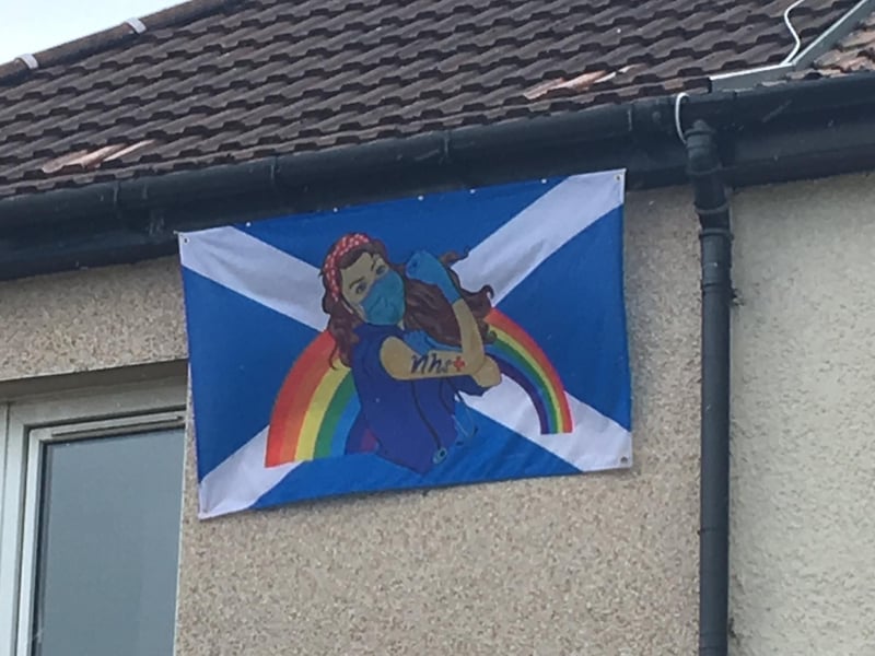 A flag flies from the guttering of a house.