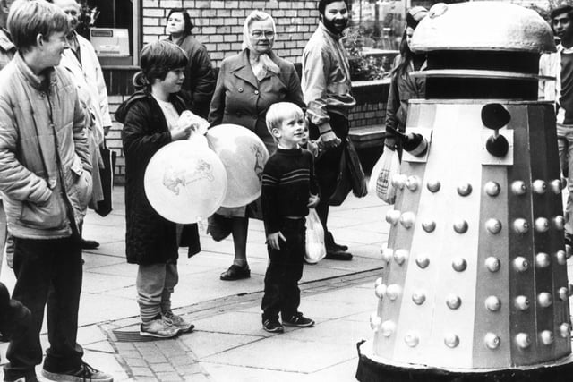 A Dalek appears on The Moor, Sheffield, much to the delight of one small boy ...October 1985