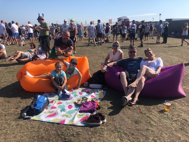 Abbie, 8, Sam, 12, their dad Matt and their mum Georgie Trigg, with Georgie's sister Anna Cockell and her partner Andy Cockell enjoying Band of Skulls at the common stage on their inflatable sofas
