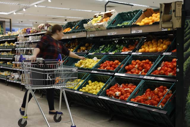 A shopper reaches for fresh fruit at a Tesco superstore. Picture: Tolga Akmen/AFP via Getty Images.
