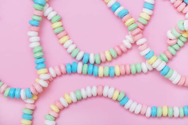 Candy necklace on pink pastel colored background. Top view.