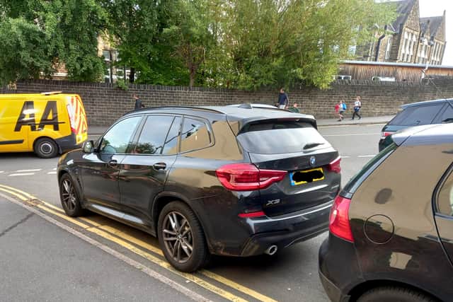 BMW parked on double yellow lines at a busy junction at school run time by Hunters Bar school.