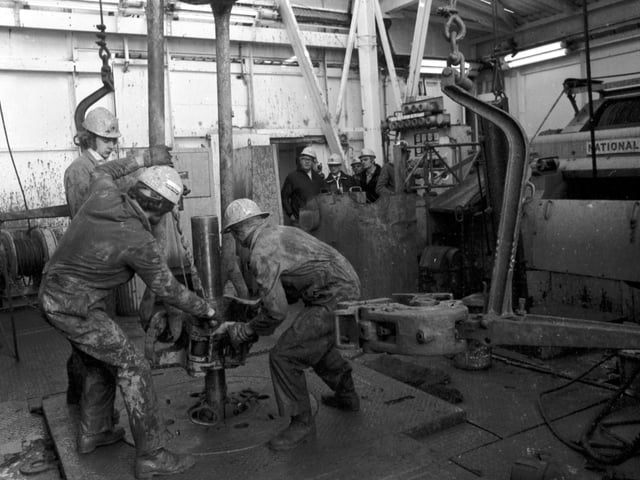 Workers add another section of pipe to the drill at BP's Forties Field oil platform in October 1975.