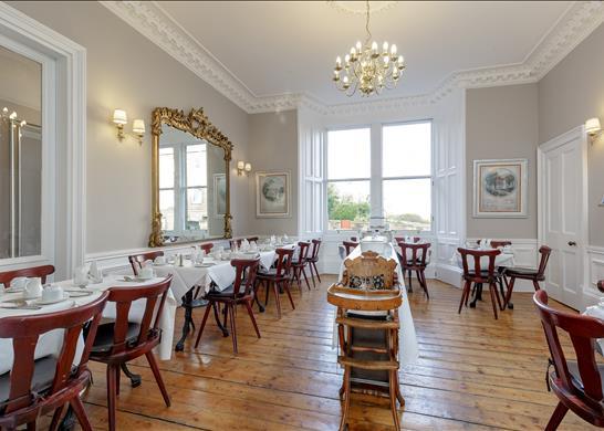 The spacious dining room has sash and case windows and cornicing.