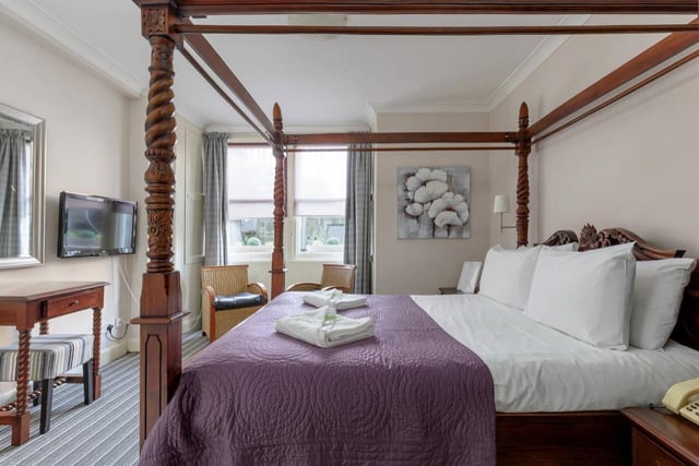 Guests can relax in this luxurious four-poster king bed in one of the spacious rooms.
