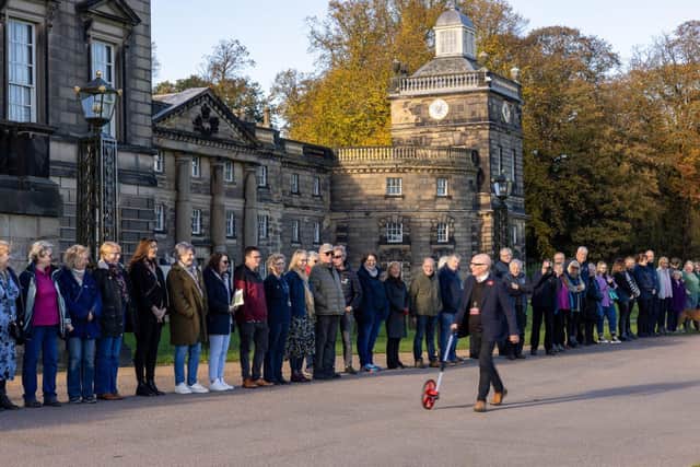 Tony Barton measures Wentworth's facade as employees, volunteers and supporters line up