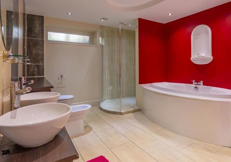 The impressive en-suite to the main bedroom. It boasts two wash hand basins, a vanity unit, a low-flush WC, a bidet, bath, walk-in shower and opaque window.