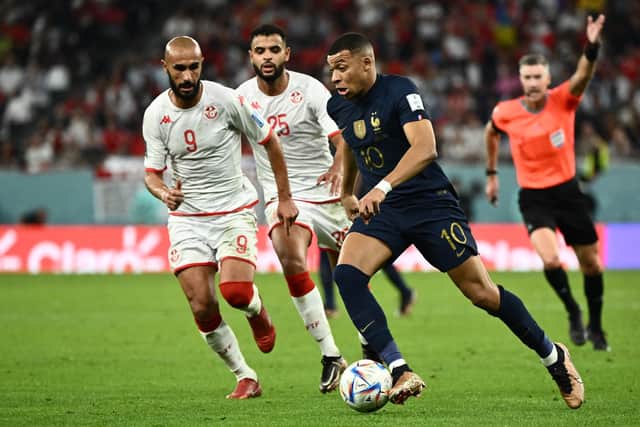 France's Kylian Mbappe is challenged by Tunisia's Issam Jebali and Anis Ben Slimane during the Qatar 2022 World Cup: JEWEL SAMAD/AFP via Getty Images